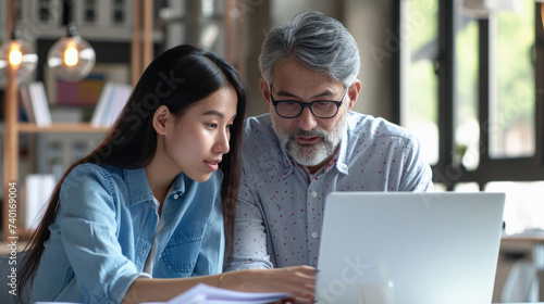 Senior Asian man and woman working together with laptop computer at home .