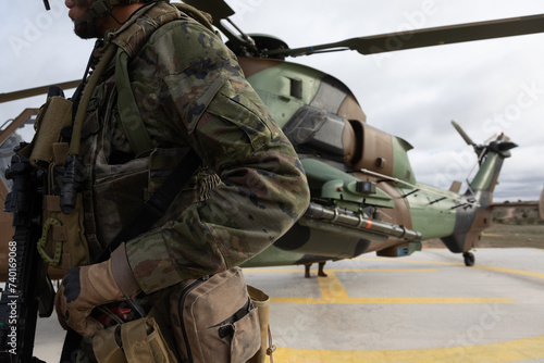 Un militar armado al lado de un helicóptero de ataque Tigre.
