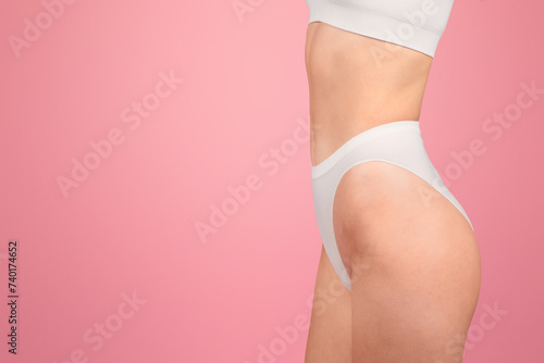 Close-up side view of a woman wearing white underwear, showcasing a simple
