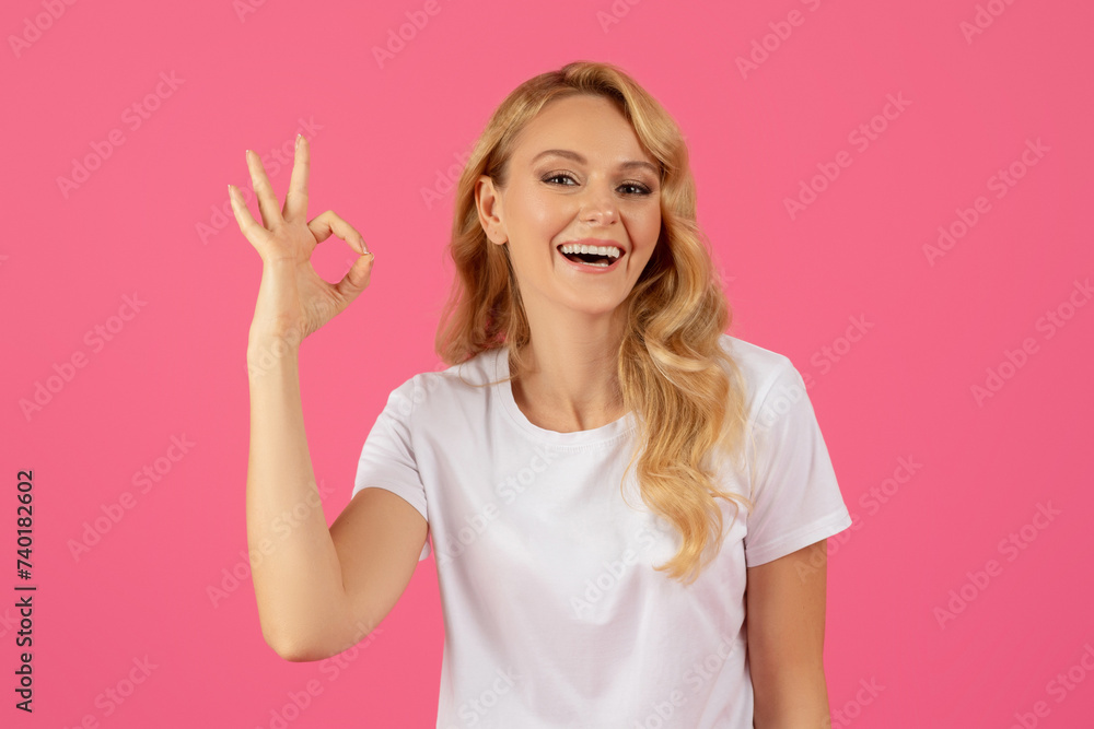 Cheerful Millennial Blonde Lady Gesturing Okay Over Pink Studio Backdrop Cheerful Millennial Blonde Lady Gesturing Okay Over Pink Studio Backdrop