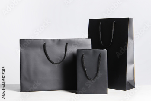 Black paper bags on white wooden table