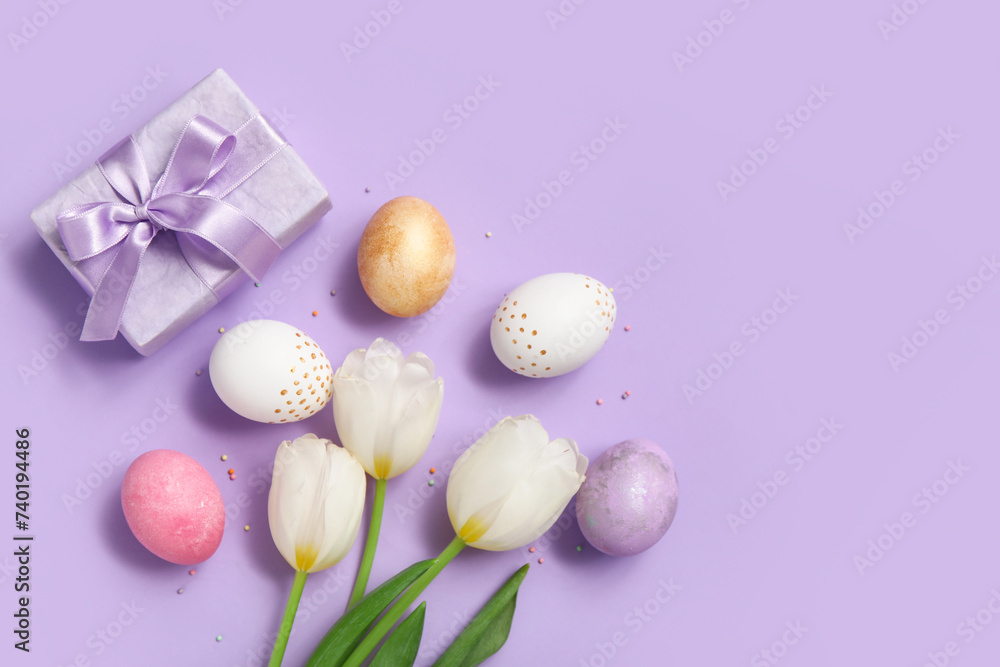 Beautiful tulip flowers with painted Easter eggs and gift box on purple background