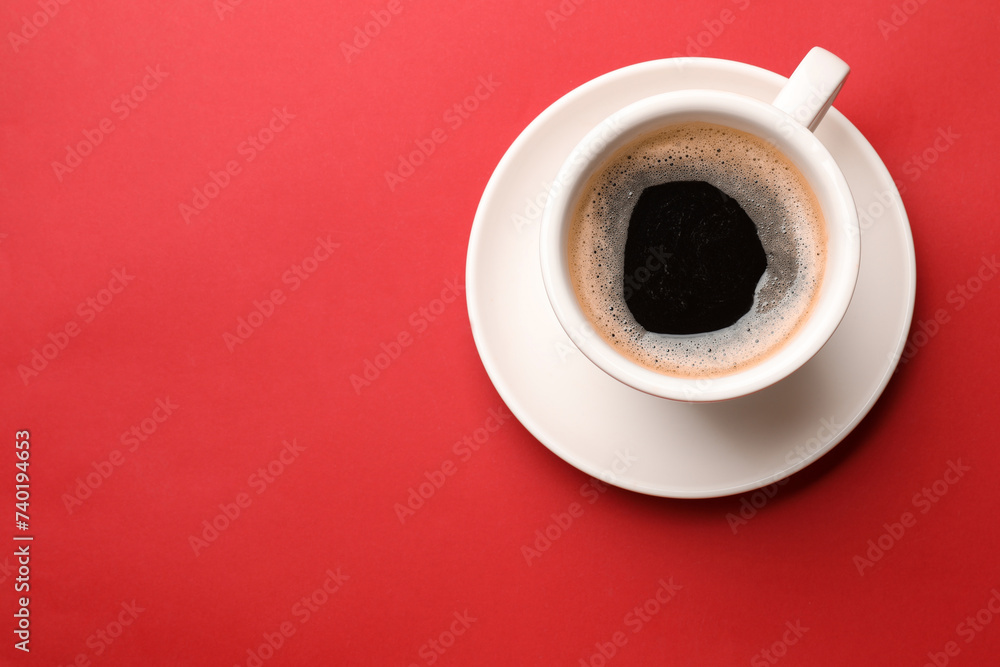 Fresh coffee in cup on red background, top view. Space for text Fresh coffee in cup on red background, top view. Space for text