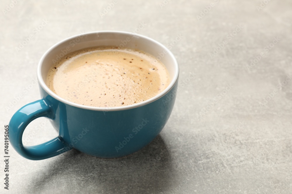Obraz premium Cup of aromatic coffee on light grey table, closeup. Space for text