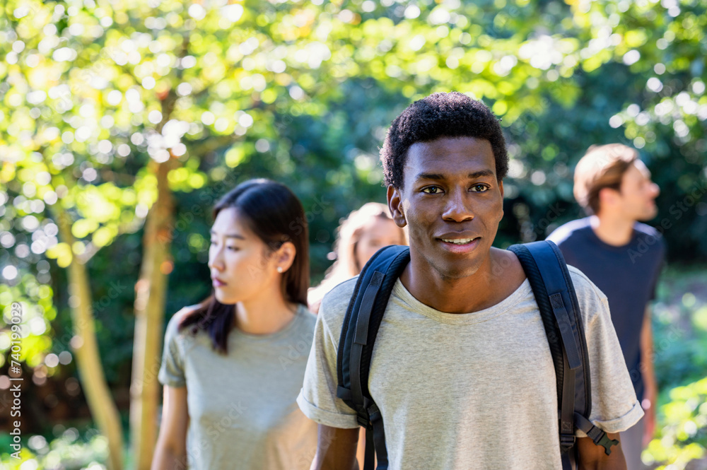 Young adult man wearing backpack during hiking with friends Young adult man wearing backpack during hiking with friends