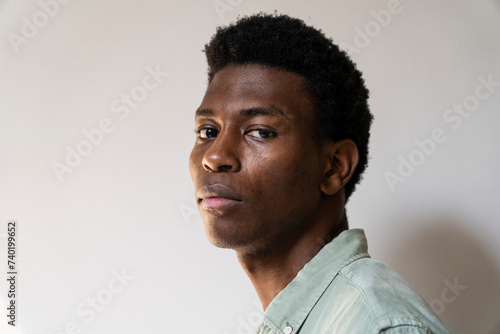 Side view portrait of young adult man looking to the camera