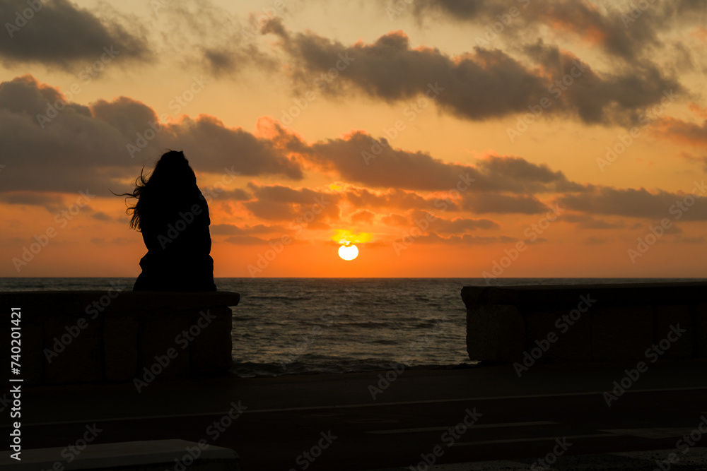 Una ragazza che guarda il tramonto a Marina di Ragusa