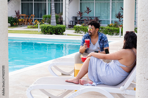 A young latin couple relaxing by the poolside