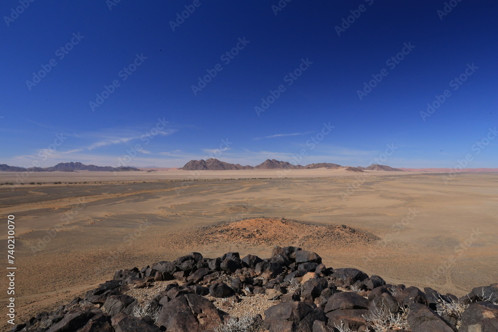 namib desert sand landscape with black rocks