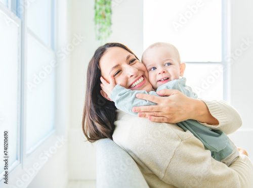 Happy young mother enjoying time with her adorable toddler son at home