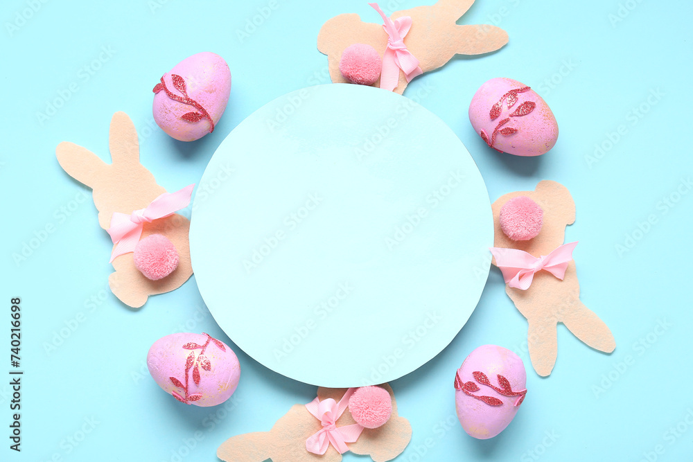Easter eggs, paper bunnies and blank card on blue background. Closeup