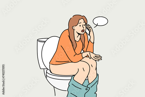 Woman sits on toilet bowl in wc and talks on phone with friend, discussing colleagues from work or fellow students from university. Girl with symptoms of diarrhea calls doctor located in toilet