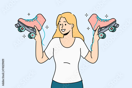 Woman holds retro roller skates, inviting you to ride together in park in fresh air. Smiling girl with vintage shoes with wheels in hands recommends buying roller skates for active lifestyle