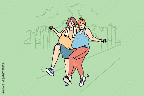 Two bigsize women run through park, doing sports to lose weight and improve well-being. Morning run bigsize girlfriends struggling with problem of obesity, enjoying healthy lifestyle and good weather
