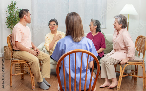 Group of happy elderly people, doctor talking together in community, consulting mental health, smiling with happiness, sitting in indoor nursing home. Retirement, Healthcare Concept.