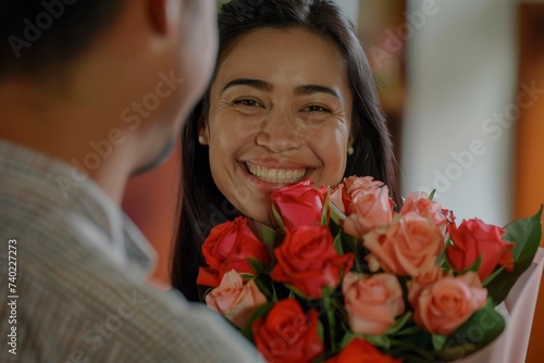 A radiant woman arranges a vibrant bouquet of fresh roses, her smile reflecting the joy of a beautiful indoor floral design for a wedding