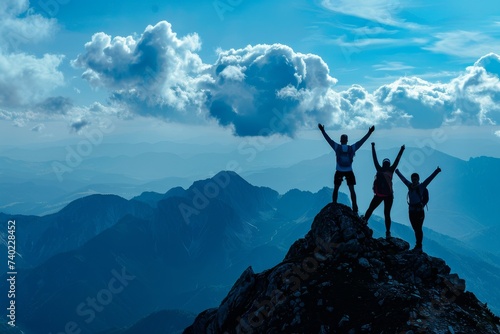 Three joyous people celebrating success on a mountaintop