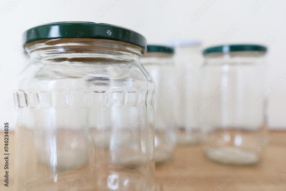 multiple transparent empty glass jars on wooden counter multiple transparent empty glass jars on wooden counter
