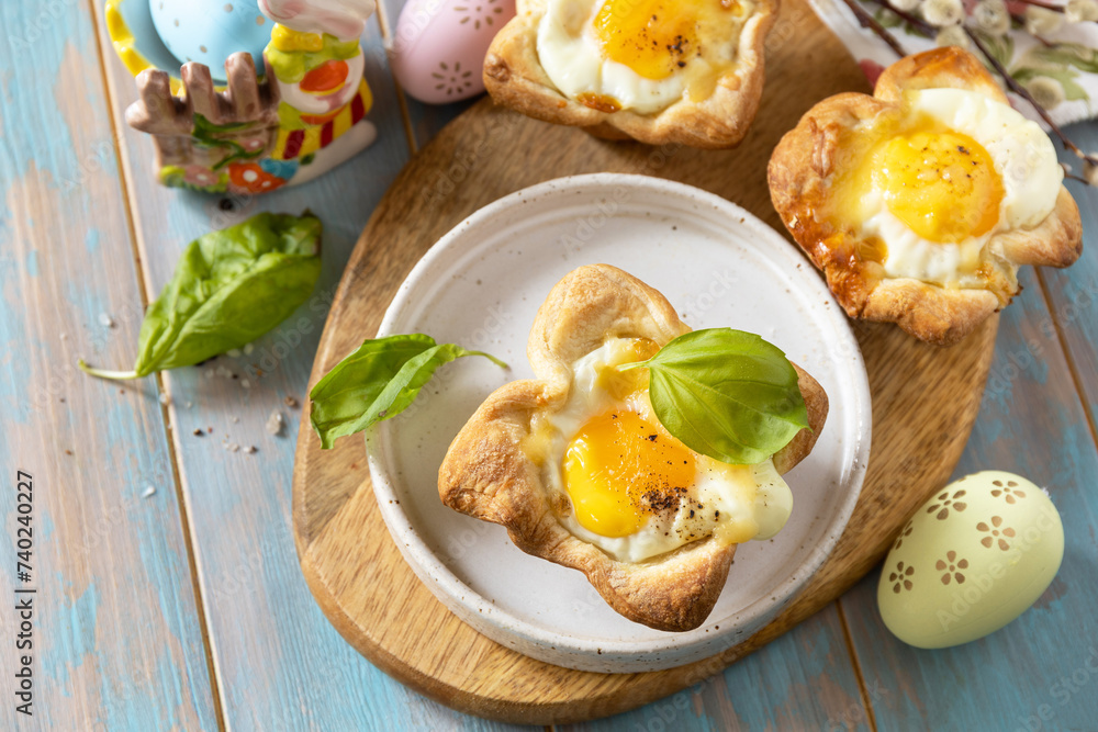 Scrambled eggs in puff pastry with cheese and bacon. Easter breakfast on a festive table. View from above. Scrambled eggs in puff pastry with cheese and bacon. Easter breakfast on a festive table. View from above.