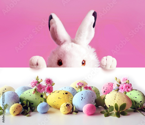 White easter rabbit with colors easter eggs and flowers. Easter concept. Easter bunny.
