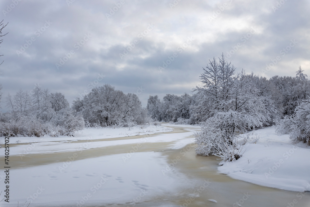 Winter landscape, a river covered with ice and snow, a beautiful sky with clouds against the background of white snow and a frozen river Winter landscape, a river covered with ice and snow, a beautiful sky with clouds against the background of white snow and a frozen river