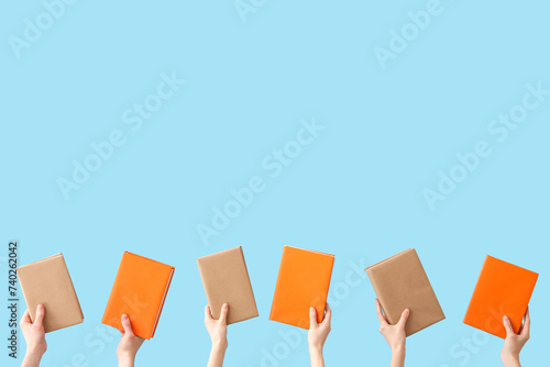 Multiple hands holding book...