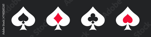 Suit deck of playing cards on dark background. Four poker symbols adorned with the suits of playing cards spades, diamonds, clubs, and hearts isolated on dark background.