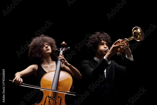 Female artist playing a cello and a male artist playing a trumpet