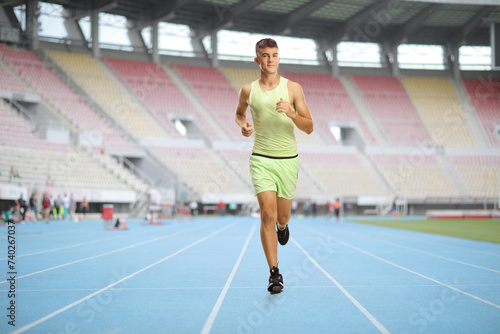 Young male athlete running on a track