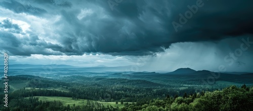 A gloomy sky with storm clouds covers the mountain valley as a powerful storm rolls in.