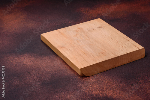 Empty rectangular wooden cutting board on textured concrete background
