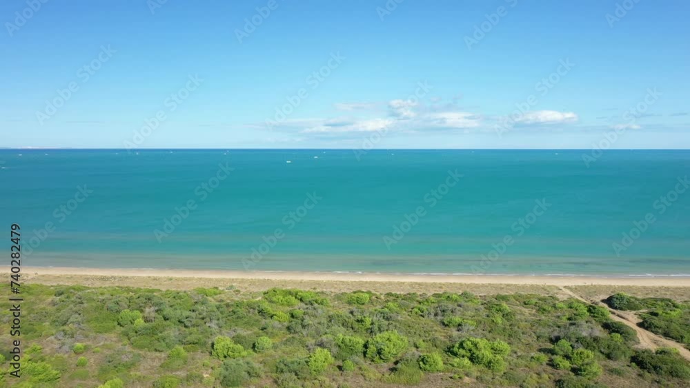The sandy beach of Isola Varano Nature Reserve by the Adriatic Sea in Europe, Italy, Puglia, towards Foggia, in summer, on a sunny day. The sandy beach of Isola Varano Nature Reserve by the Adriatic Sea in Europe, Italy, Puglia, towards Foggia, in summer, on a sunny day.