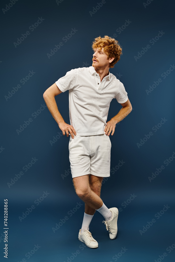 trendy well-dressed man in white shorts and polo t-shirt looking away on blue, full length trendy well-dressed man in white shorts and polo t-shirt looking away on blue, full length