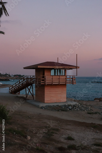 Wooden lifeguard safety tower station along the boardwalk beach of Paphos, Cyprus during sunset