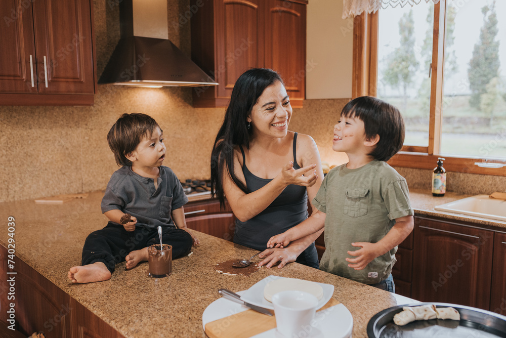 Fototapeta premium Mom and sons cooking together, having a good time