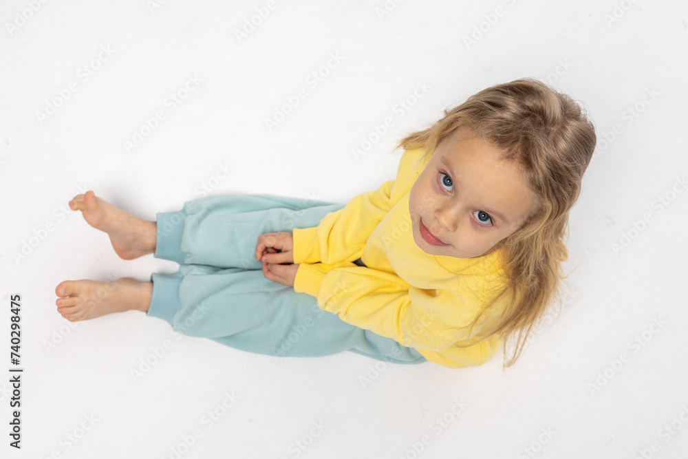 Portrait of beautiful cute little toddler girl. Child with funny face in yellow sweatshirt. Pretty smile kid in studio on white background. High quality photo Portrait of beautiful cute little toddler girl. Child with funny face in yellow sweatshirt. Pretty smile kid in studio on white background. High quality photo
