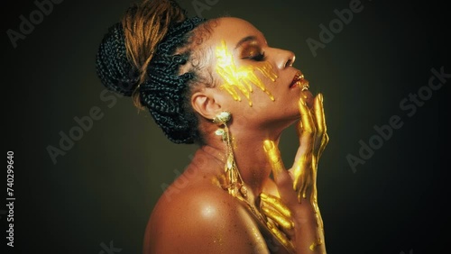 fantasy art portrait lips eyes close up face african american woman. Professional creative golden make-up shiny shadows. Hands in gold liquid drops flow sexy Fashion model beautyl girl. Studio black photo