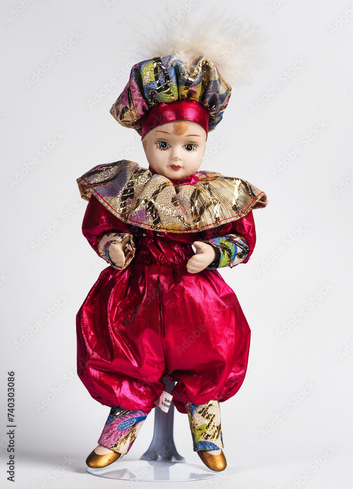 Φωτογραφία Sweet Porcelain Italian doll depicting the young hero of the Commedia Del Arte in a red suit with golden frills and a hat