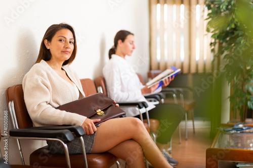 Confident latino american woman with briefcase waiting for job interview at office