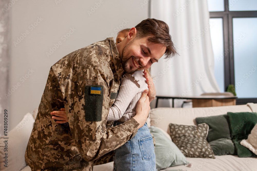 Obraz premium military man of the Ukrainian army in camouflage uniform returned home and hugs his daughter, soldier goes to war and says goodbye to his child, the concept of mobilization in Ukraine