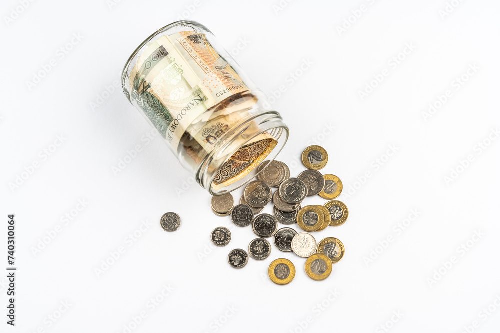 Polish zloty banknotes and coins in glass jar white background. Saving money concept. Polish zloty banknotes and coins in glass jar white background. Saving money concept.