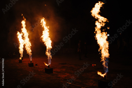 People dance a passionate dance with a fiery spinning wheel in hand. Tribal dancer. Fire show. Spin fire around a swing on the beach in a full moon. The fire shows many sparks at night