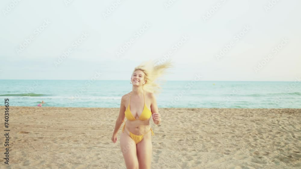 Beautiful young woman in bikini running to the camera smiling as she enjoys an afternoon on the beach during her summer holiday. Concept of summer holidays, weekend and happiness. Beautiful young woman in bikini running to the camera smiling as she enjoys an afternoon on the beach during her summer holiday. Concept of summer holidays, weekend and happiness.