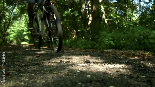 Three Bicycle Tires Pass Camera Close-up on Gravel Road