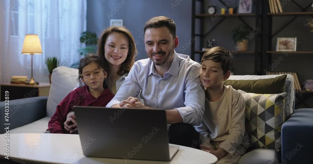 Happy smiling family using laptop waving hands talking during online video conference call chat with relatives or friends, sitting on sofa in the evening. Distance connection concept Happy smiling family using laptop waving hands talking during online video conference call chat with relatives or friends, sitting on sofa in the evening. Distance connection concept