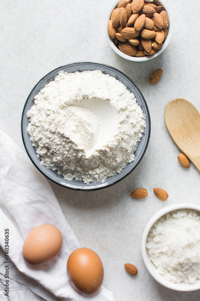 overhead view of mise en place for almond biscotti dough, ingredients for making almond cantucci cookie on a marble countertop overhead view of mise en place for almond biscotti dough, ingredients for making almond cantucci cookie on a marble countertop