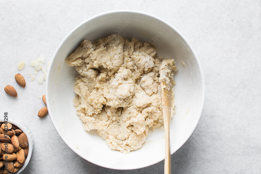 overhead view of almond biscotti dough in a white bowl, almond cantucci cookie dough in ceramic mixing bowl, flatlay of biscotti cookie dough or twice baked cookies overhead view of almond biscotti dough in a white bowl, almond cantucci cookie dough in ceramic mixing bowl, flatlay of biscotti cookie dough or twice baked cookies