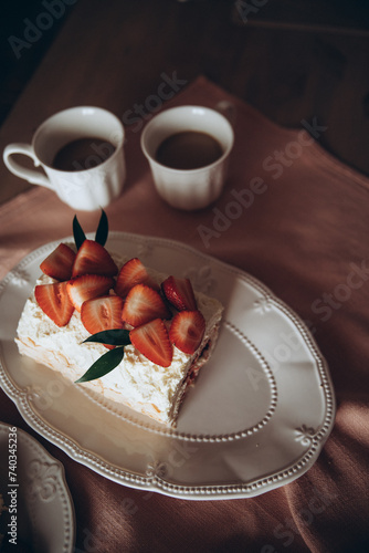 meringue cake combined with fresh strawberries on a background of a pink tablecloth