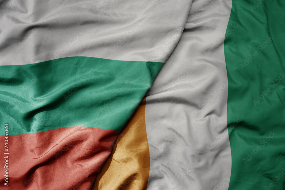 big waving national colorful flag of cote divoire and national flag of bulgaria .