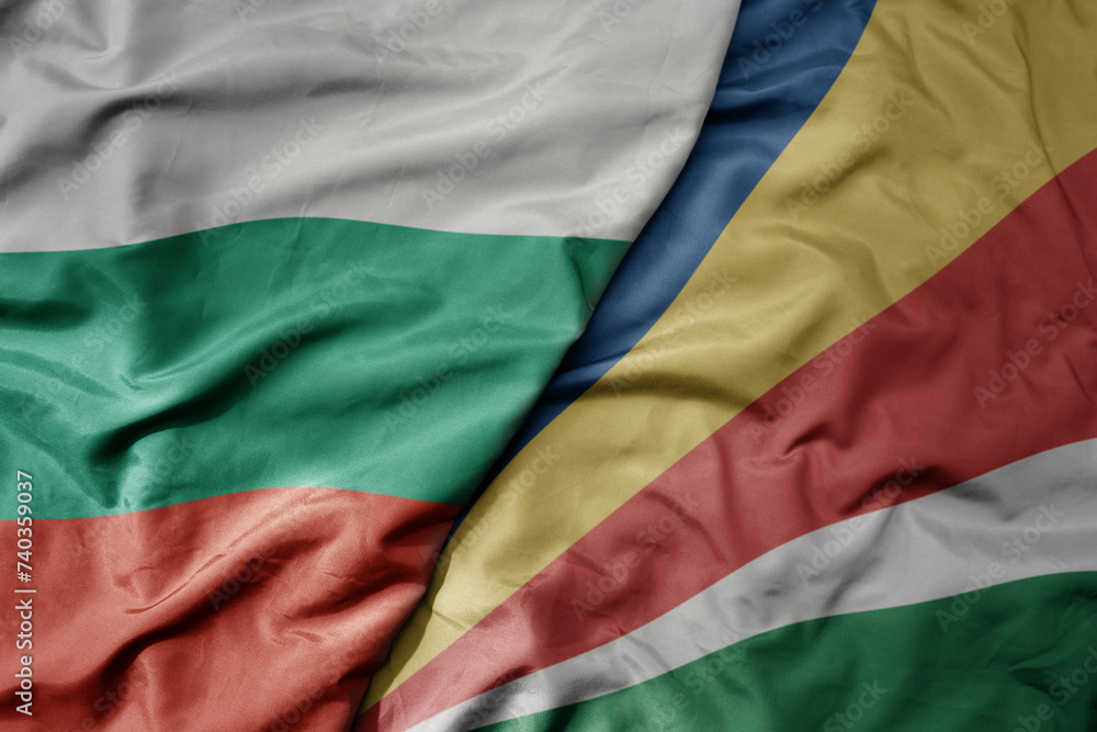 big waving national colorful flag of seychelles and national flag of bulgaria .